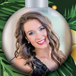 A smiling woman with long brown hair and red lipstick appears inside a round Christmas ornament, with green pine needles and a gold star in the background.